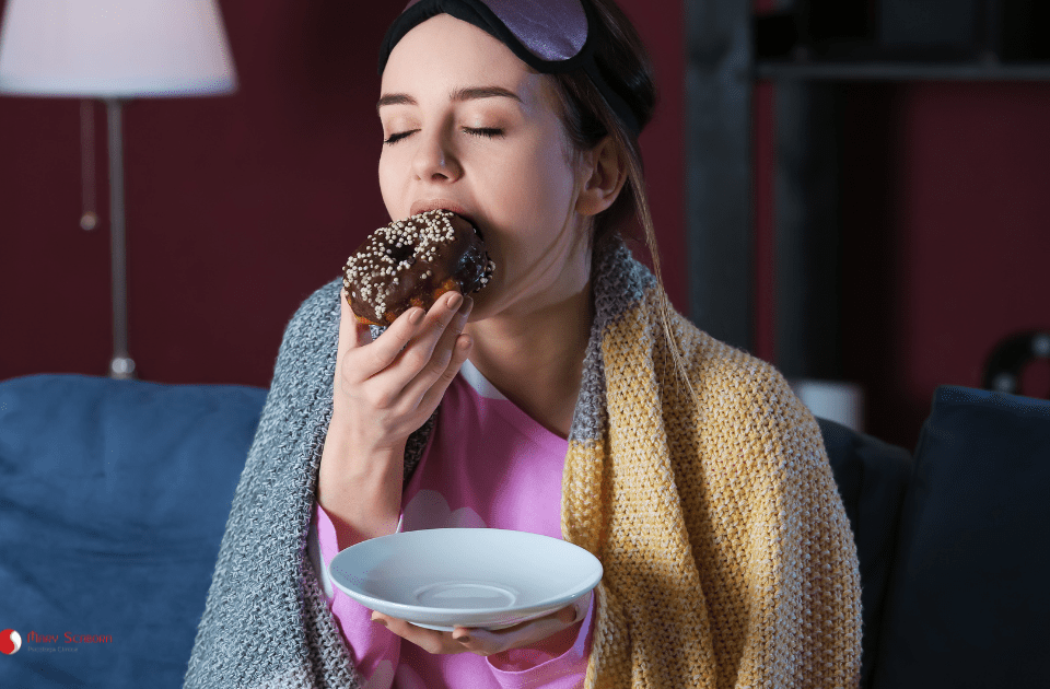 mulher comendo guloseima a noite para ilustrar a síndrome do comer noturno