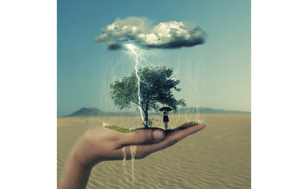 Uma mão segurando uma pequena paisagem com uma árvore, um guarda-chuva e uma nuvem de tempestade, contrastando com o deserto ao redor representando o tratamento para o transtorno do pânico