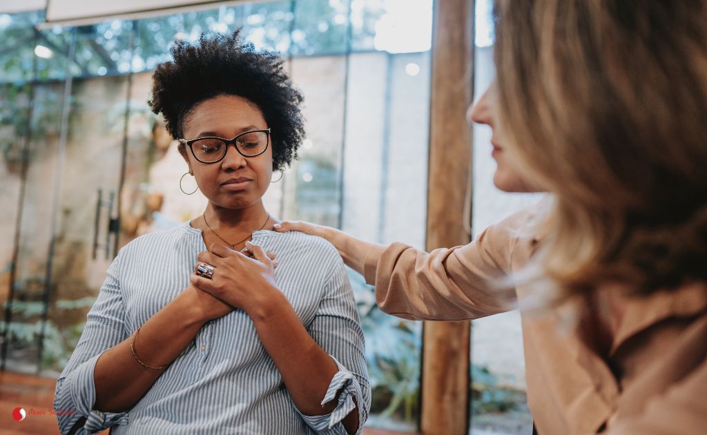 amiga dando suporte para outra durante uma crise de ansiedade, oferecendo apoio emocional e técnicas para gerenciar os sintomas e promover o bem-estar.