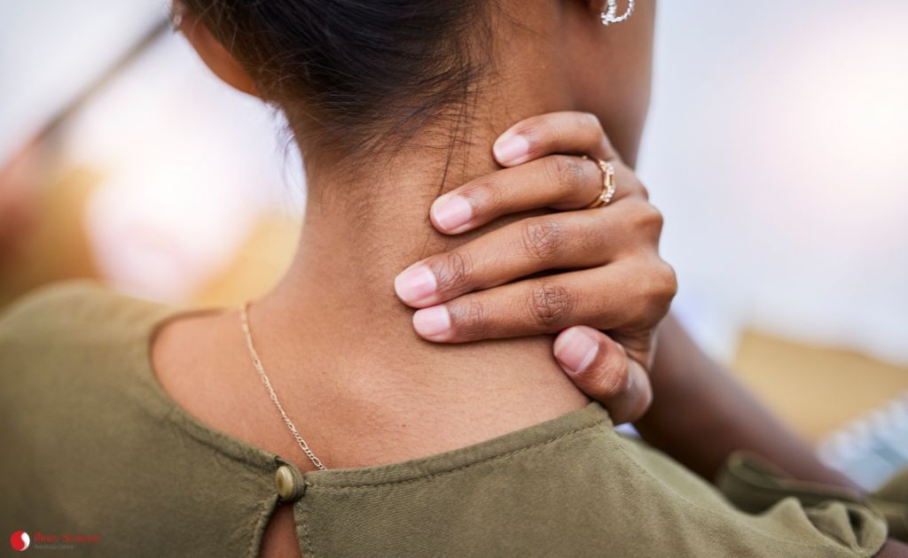 mulher tensa apertando a nuca representando a importância da massagem para alivio do estresse e ansiedade