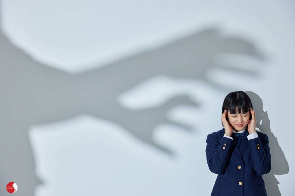 Metáfora visual da catastrofização: sombra ameaçadora se aproximando de uma mulher