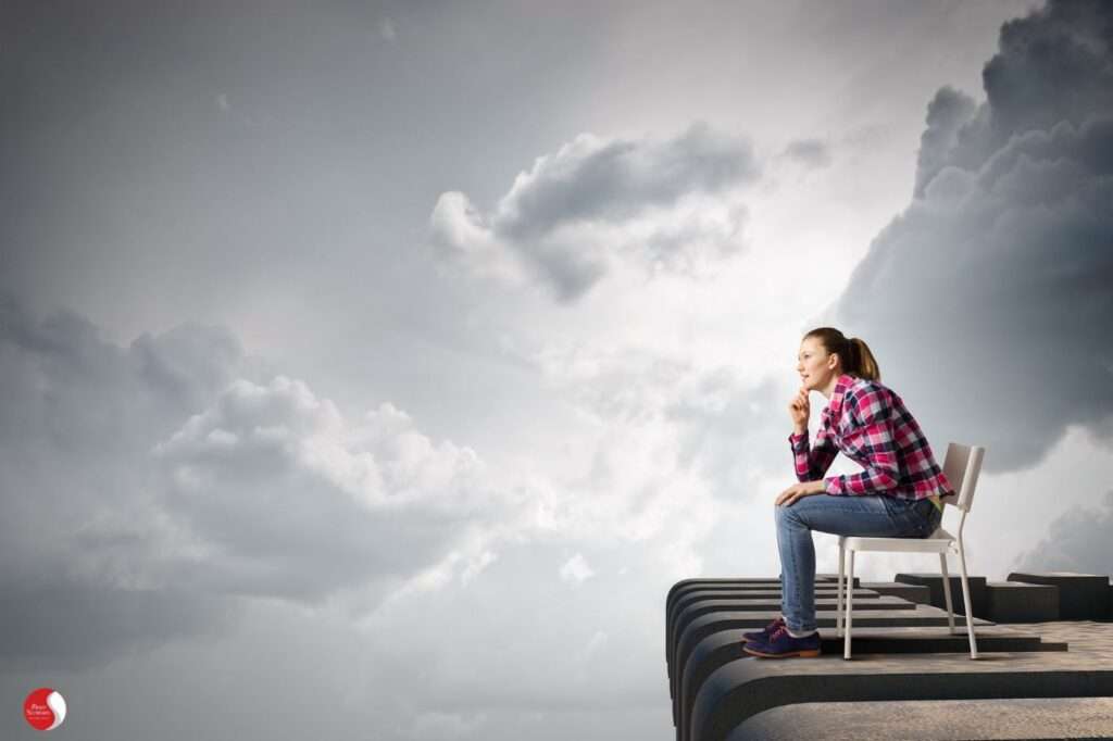 Catastrofização como antecipação: mulher pensativa diante de um céu carregado