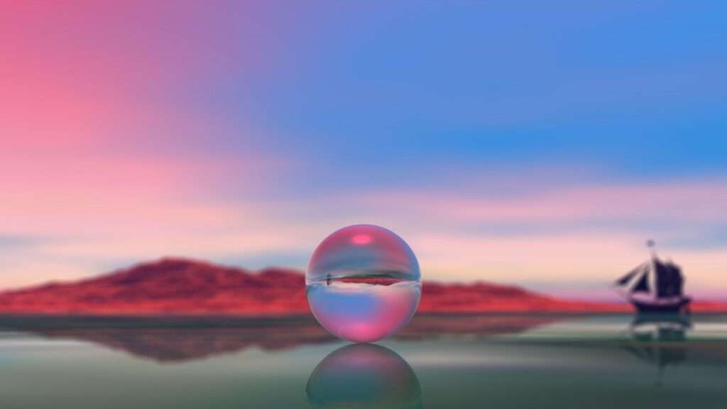 Esfera de vidro refletindo uma paisagem, com montanhas e barco ao fundo.